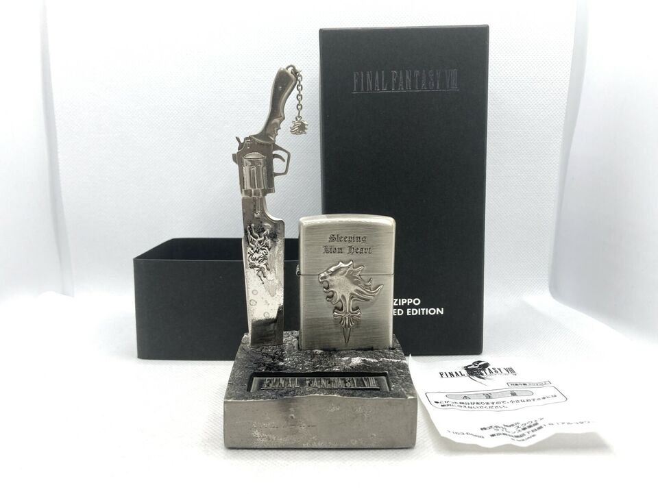 A Zippo lighter emblazoned with the Griever lion symbol. It is embedded in a metal stand that looks like rocky terrain, with a replica of Squall's gunblade embedded in the earth, like in the opening sequence of the game.