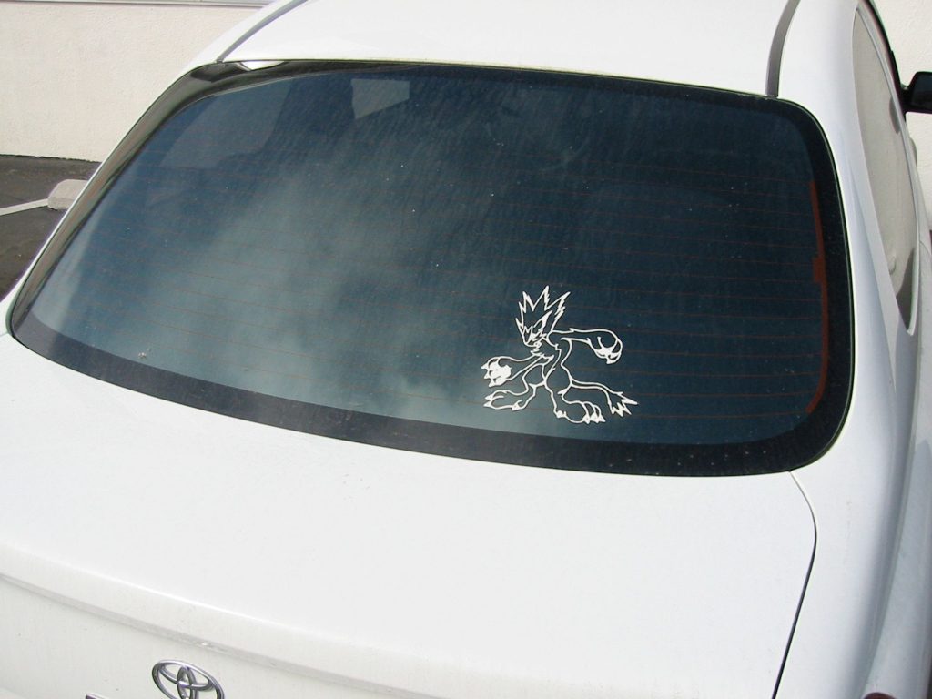 A white Toyota Echo with a Moomba decal on the rear window.