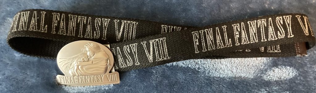 A fabric belt with "Final Fantasy VIII" written on it, with a huge cheap-looking buckle with the Amano FF8 icon art on embossed on it.