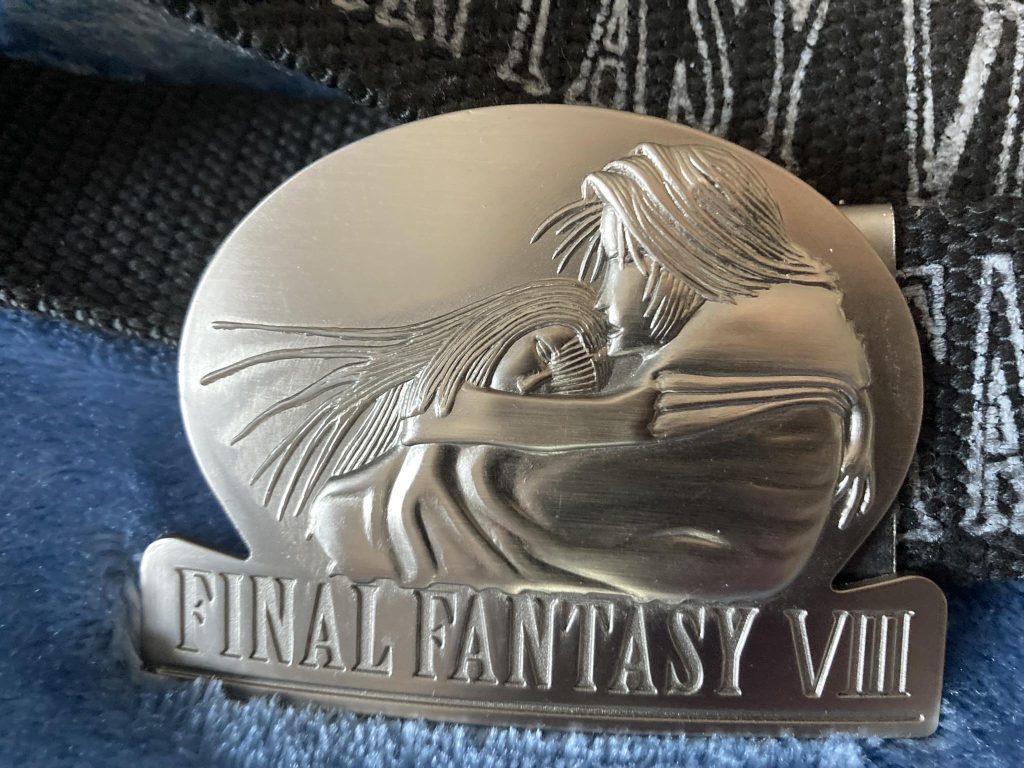 A close-up of the belt buckle. Squall looks pained.