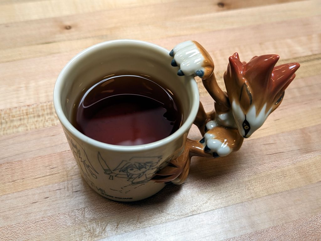 The Moomba mug filled with a rich orange tea.