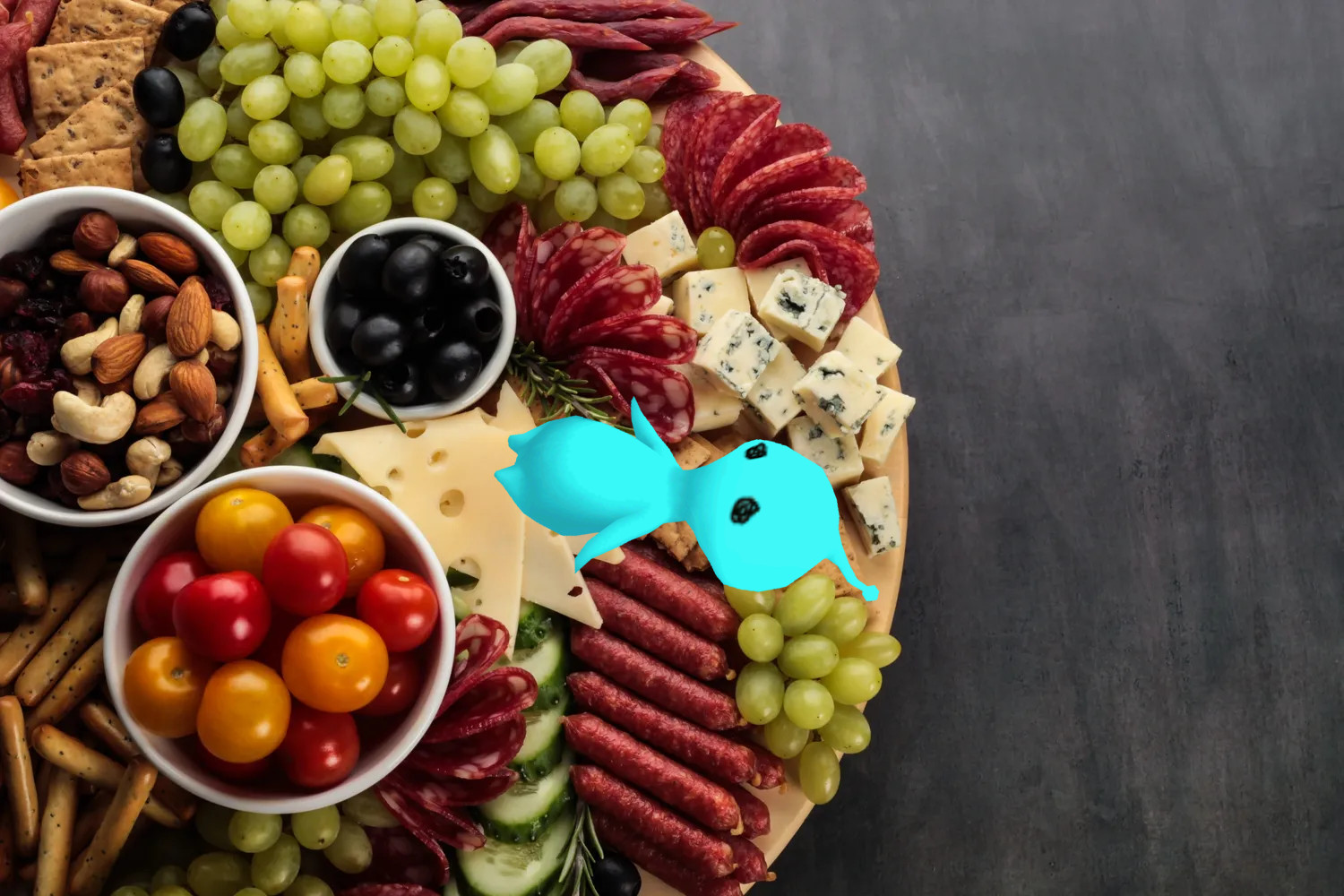 PuPu on a charcuterie board, surrounded by various meats and cheeses.