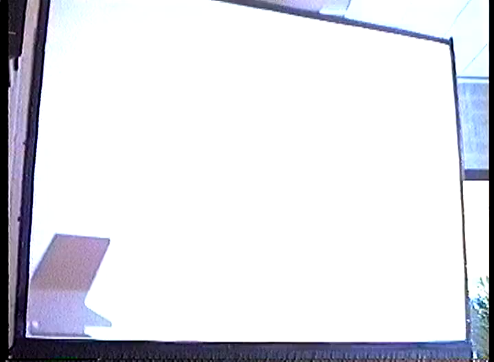 A blank projector screen lit up by flash photography.